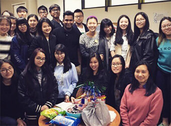 Snow (seated at far right) poses with multicultural club members in Melbourne