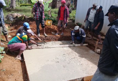 Volunteers working on a concrete slab basement at Yaken Aid post.  © Anglicare PNG. 2018.