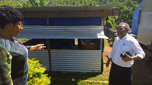 Rev Claude shows Heni Meke from Anglicare PNG some improvised houses