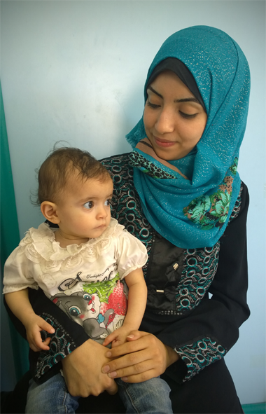A little girl with her mother at Al Ahli Hospital