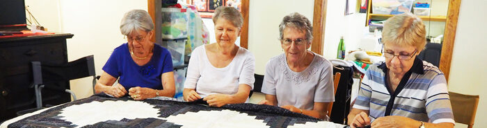 Volunteers making a quilt to fundraise at the Maryborough Auxiliary Centenary Celebrations, 2018.