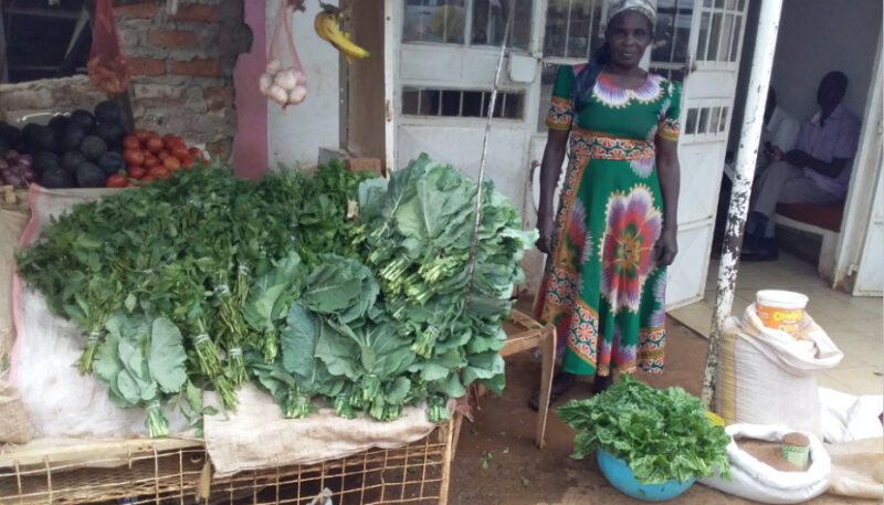 Margaret with vegetables she sells from her shop 