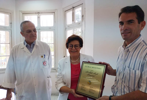 Al Ahli Hospital Director, Ms. Suhaila Tarazi, receiving the award from Canon Peter Makari.