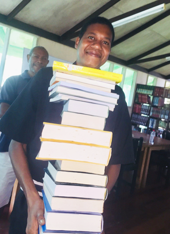 Many books produce a very large smile from Br Josiah. © Bishop Jeffrey Driver, 2018. Used with permission.