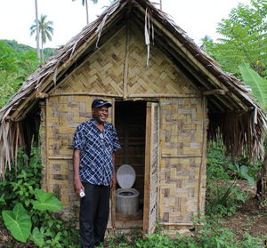 Joses Togase, former WASH coordinator, proudly shows a recently installed VIP toilet. © ABM, Jessica Sexton, 2015.