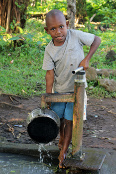 A boy fills his saucepan in Namasari Village, Gaua Island, Vanuatu. © Greg Henderson/ABM 2015.