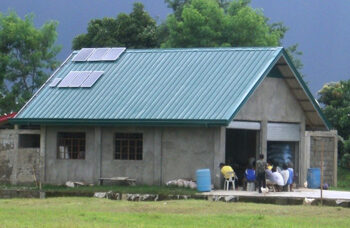 The roof of this warehouse, on which is installed the solar panels for the power charging station, was completely blown off by a typhoon. The community kept appealing to the development program to rehabilitate the building. It is now being restored by the community through a non-interest bearing loan under the ECP’s “Receivers-to-Givers” Policy.