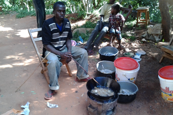 Musau Kombo cooking fish for his customers at Kanoto Market. ©ABM/Beth Snedden 2014