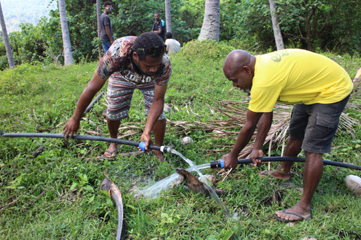 Gino, an ACOM-V WASH volunteer, and Steven, the Nawelala Community WASH focal person, repair a leak in the water system in Big Bay Bush, Santo. © Kate Winney/ABM, 2018.